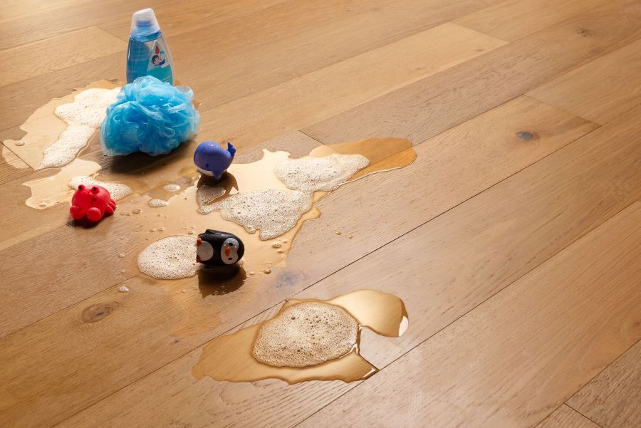 Soapy water on a wood floor with kids toys; Bruce Hydropel waterproof engineered hardwood flooring