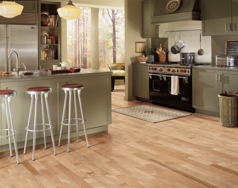 Kitchen showing an island and range with light maple flooring