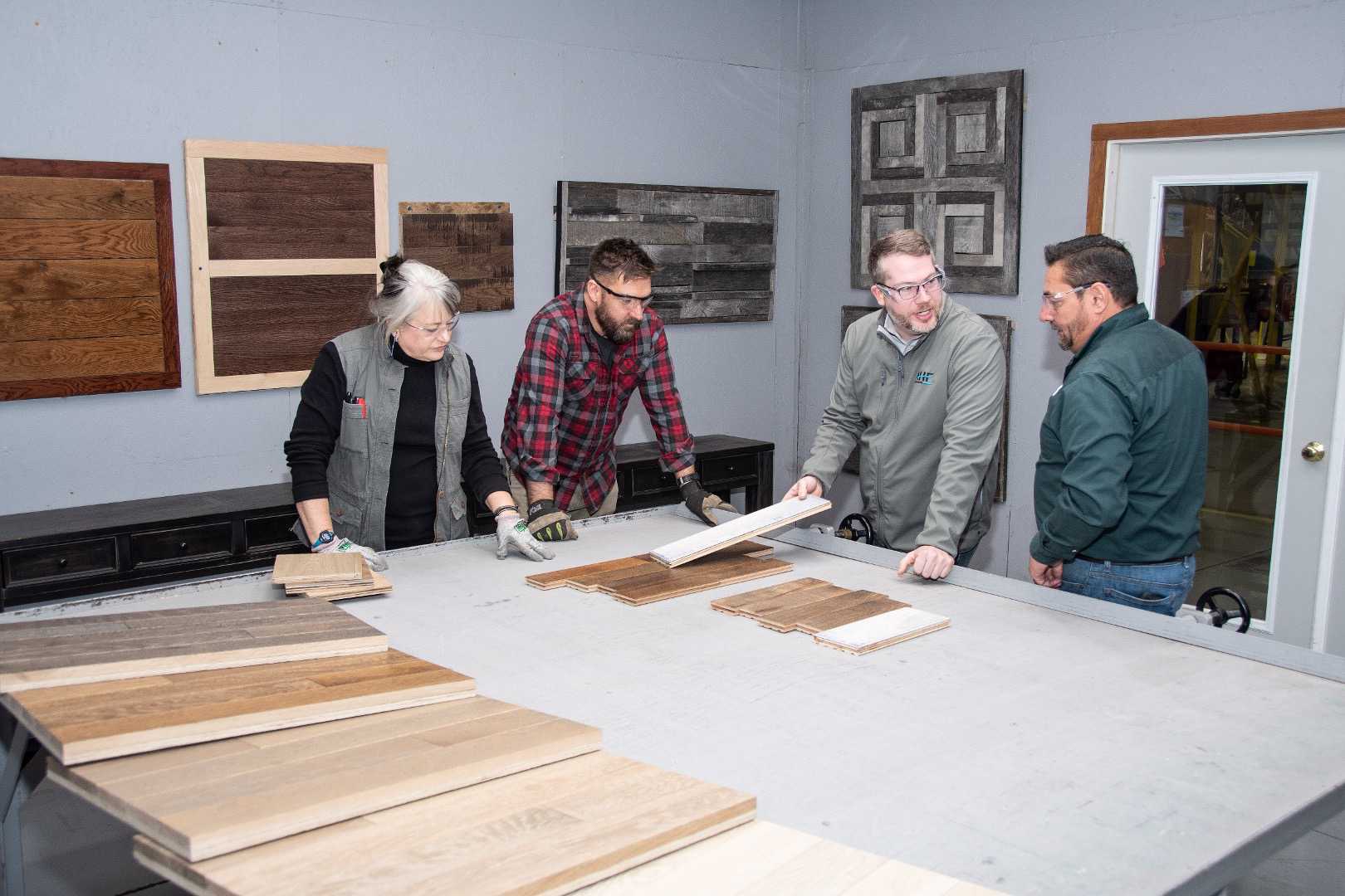 Mark Bowe at a table with AHF Products team members reviewing wood samples for Barnwood Living