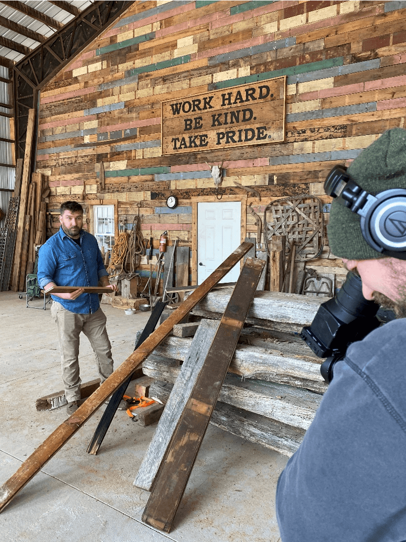 Mark Bowe in his shop with a camera man to discuss Barnwood Living collection of barnwood flooring