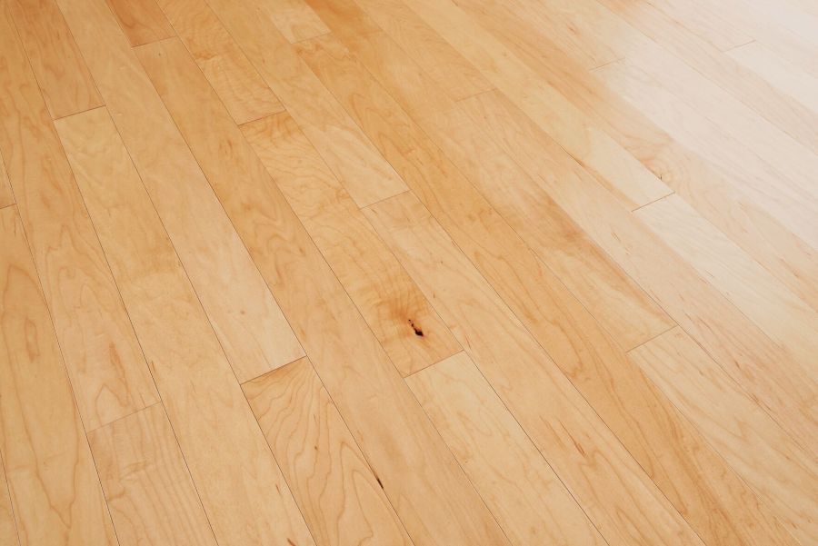 Close-up of a natural maple wood floor showing its light color and minimal grain