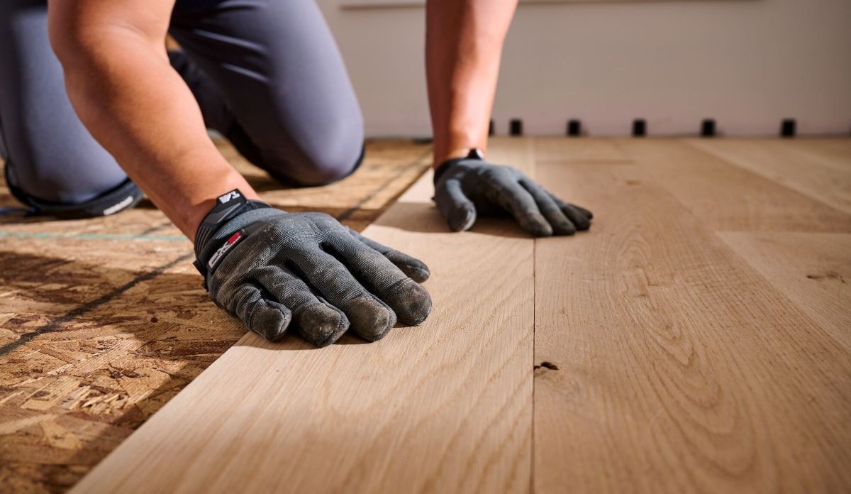 Man installing unfinished hardwood flooring
