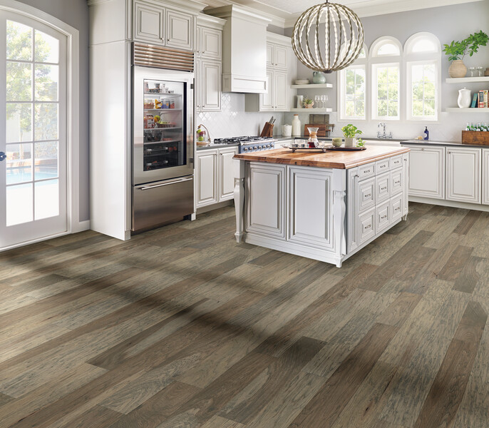 Kitchen area with an island and wide plank wood flooring