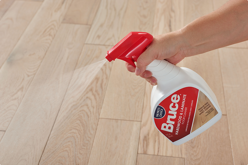 person spraying bruce cleaner on hardwood floors