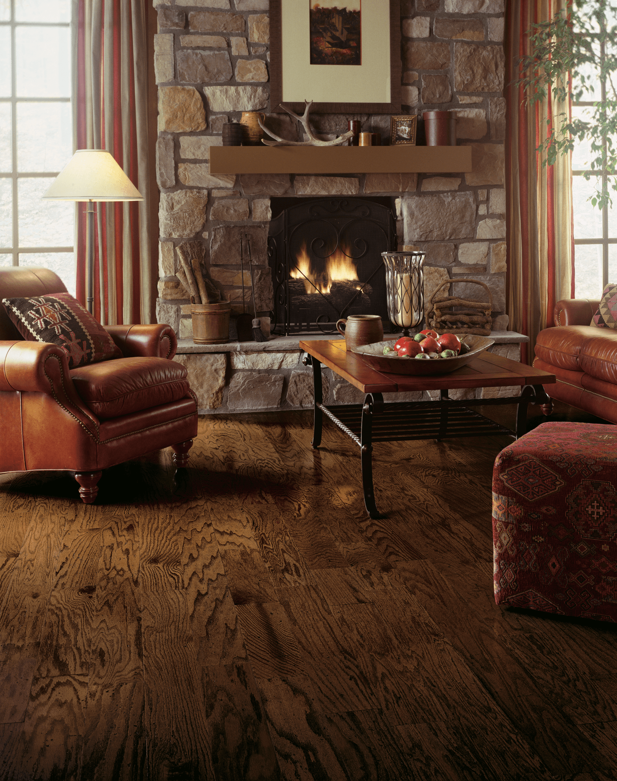 Den with a fireplace and seating showing red oak engineered hardwood flooring from Bruce