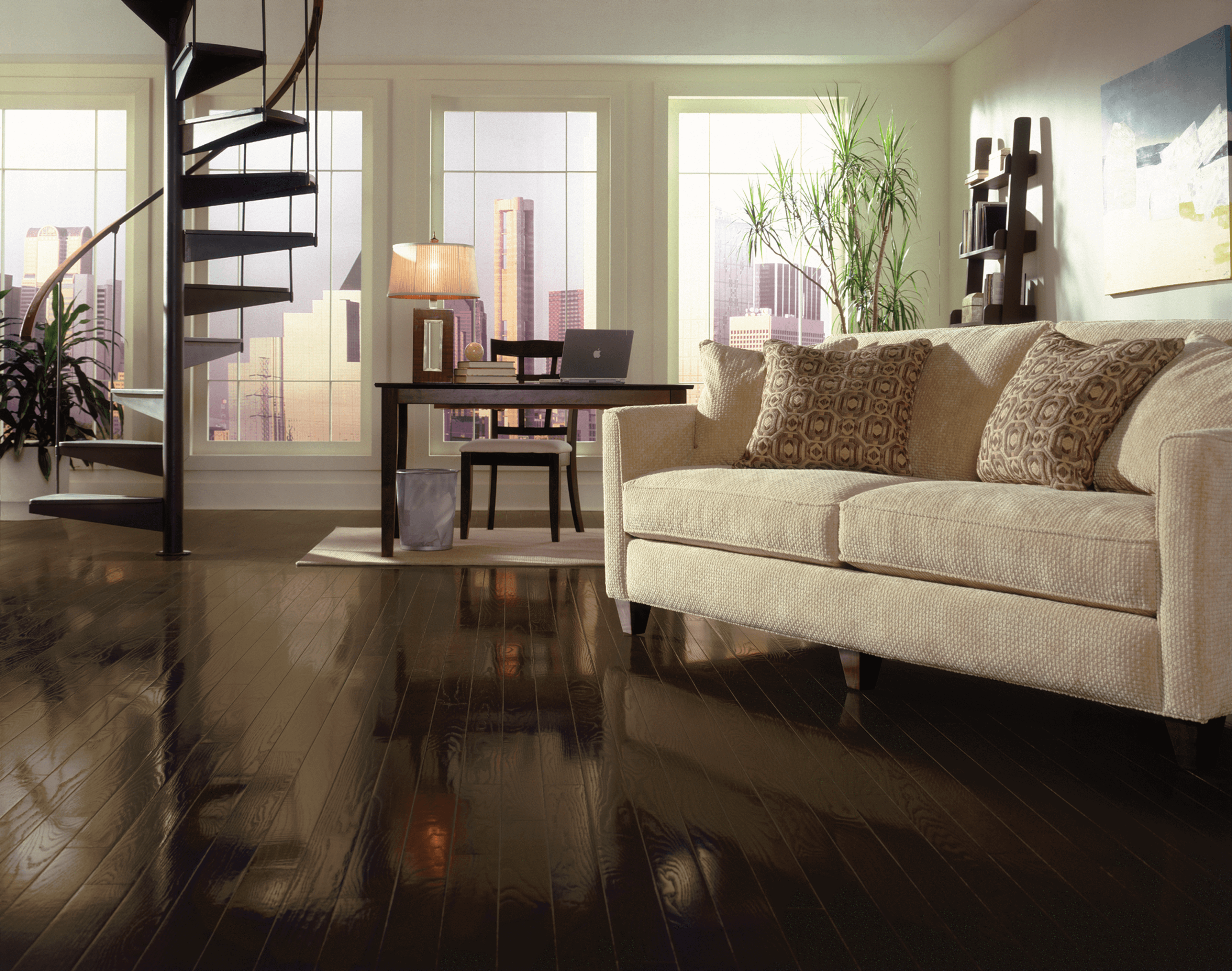 Modern living room with a spiral staircase overlooking a city scape and using red oak flooring from Bruce